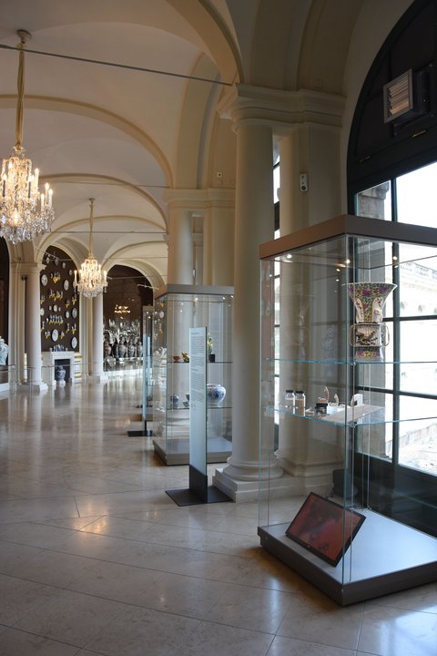 Glasvitrine mit der restaurierten Vase in den Ausstellungsräumen der Porzellansammlung im Dresdner Zwinger, neben der Vase sind Druckstücke des Rüssels zu sehen.