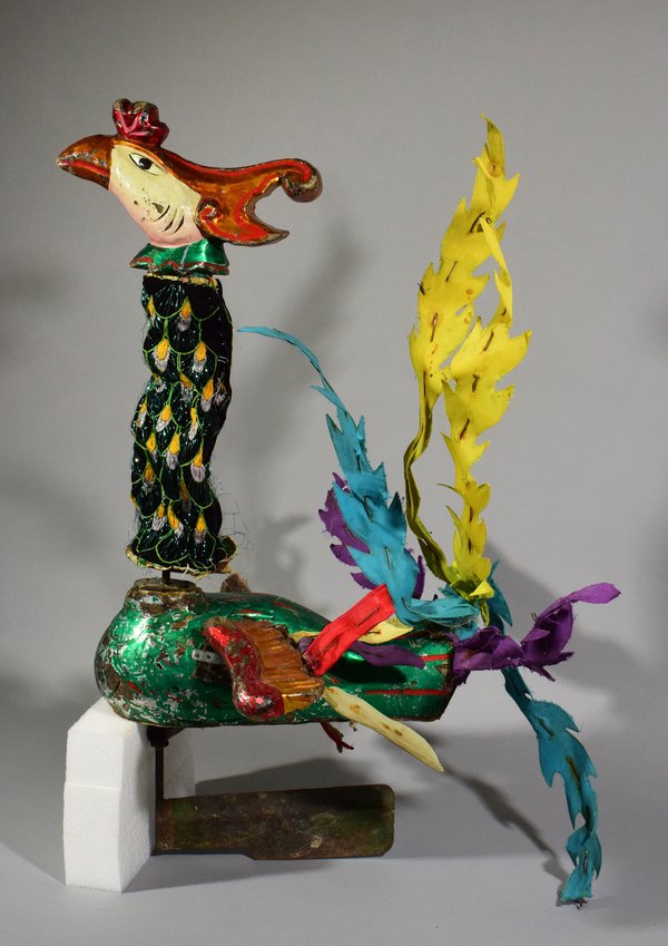 Eine farbenfrohe Phönixfigur aus bemaltem Holz, Textil, Metall, Kunst- und Schaumstoff mit beweglichem Hals und beweglichen Flügeln.