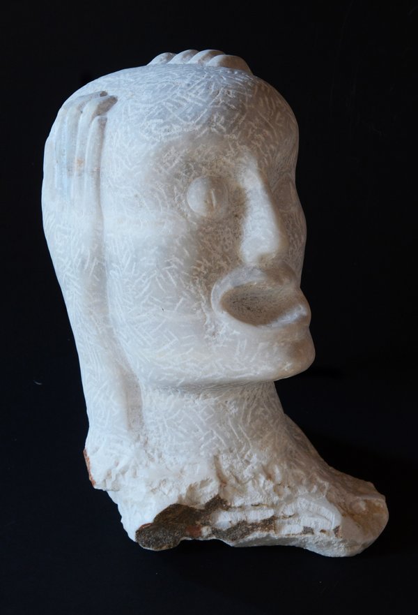 Erika Harbort: Schrei. Die Skulptur eines schreienden Kopfes aus griechischem Marmor. Die Figur hat die Hände seitlich an den Kopf gelegt und den Mund weit geöffnet.