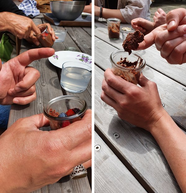 Ein Gast des Lunch for Locals löffelt mit dem Finger Mousse au Chocolat aus dem Servierglas.