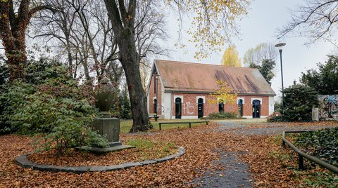 Das Gebäude der art Kapella Schkeuditz: Ein kleiner Kapellenbau mit Spitzdach auf dem Gelände des alten Friedhofs.