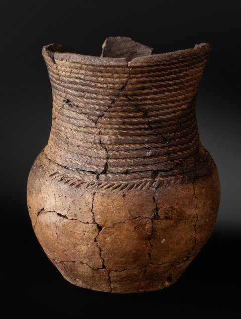 The Corded Ware culture is named after the practice of pressing twisted cords into the wet clay prior to firing pottery, as with the vessel from Greitschütz, in the Leipzig district. This well-preserved beaker was found alongside other pottery in the grave of a roughly 13-year-old youth who appears to have been female. According to carbon-14 dating, she was buried between 2574 and 2457 BC. The burial site, uncovered in 1998 by the Saxon Archaeological Heritage Office, holds 24 graves, making it the largest of its kind in Saxony from that time.