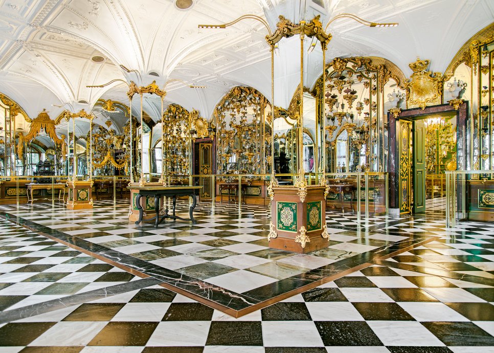 Blick in einen prunkvollen Raum mit Spiegeln und Ausstellungsstücken