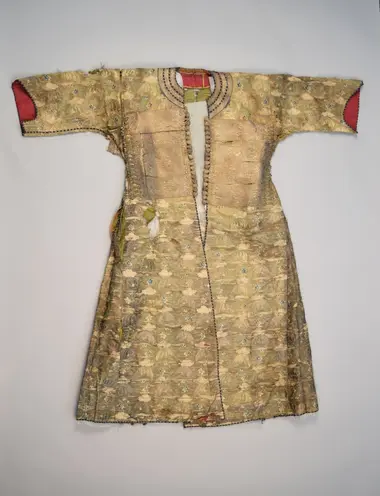 Ein langes, goldenes Hemd, beinahe Kleid-artig, mit kurzen Ärmeln und feiner organischer Muster.
