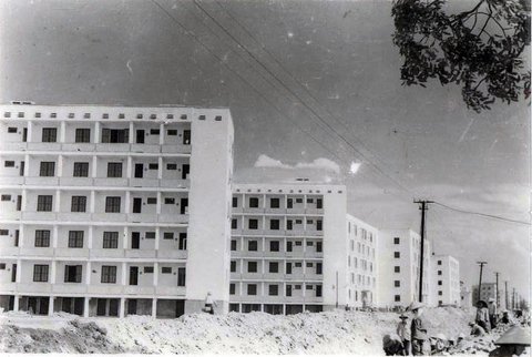 Fotographie des Quang Trung Wohnkomplexes von 1977: Entlang einer Straße werden große, helle Plattenbauten errichtet.