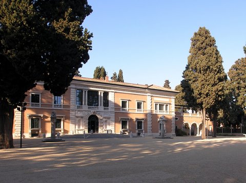 Eine italienische Villa der Renaissance nachempfunden mit Vorplatz und von Bäumen umgeben (Die Villa Massimo)
