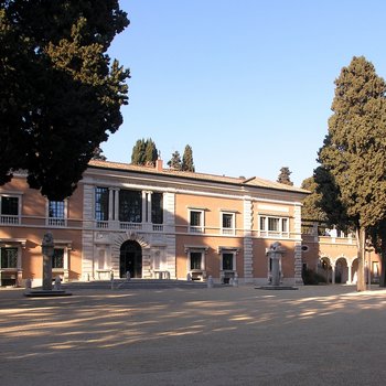Eine italienische Villa der Renaissance nachempfunden mit Vorplatz und von Bäumen umgeben (Die Villa Massimo)